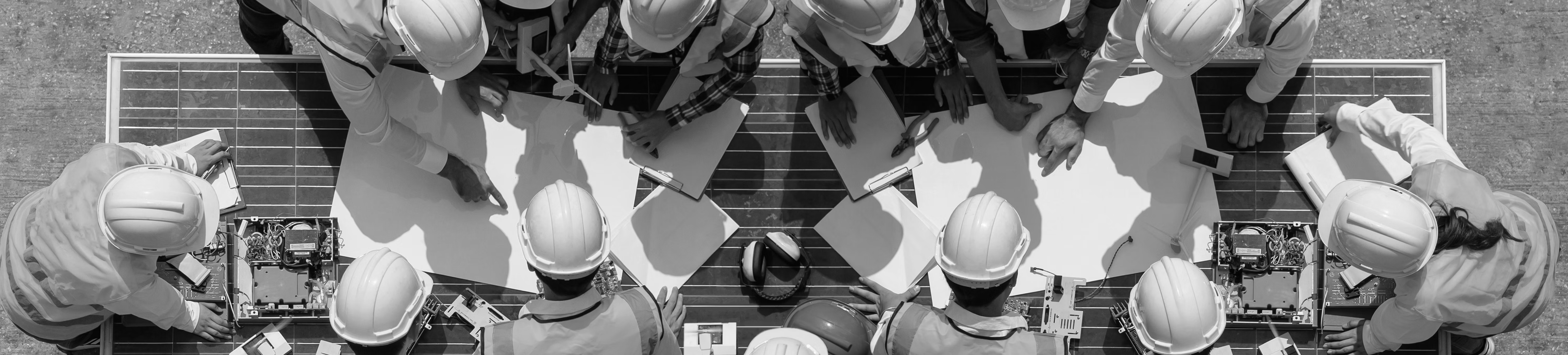 Construction crew reviewing safety plans on a job site, overhead view